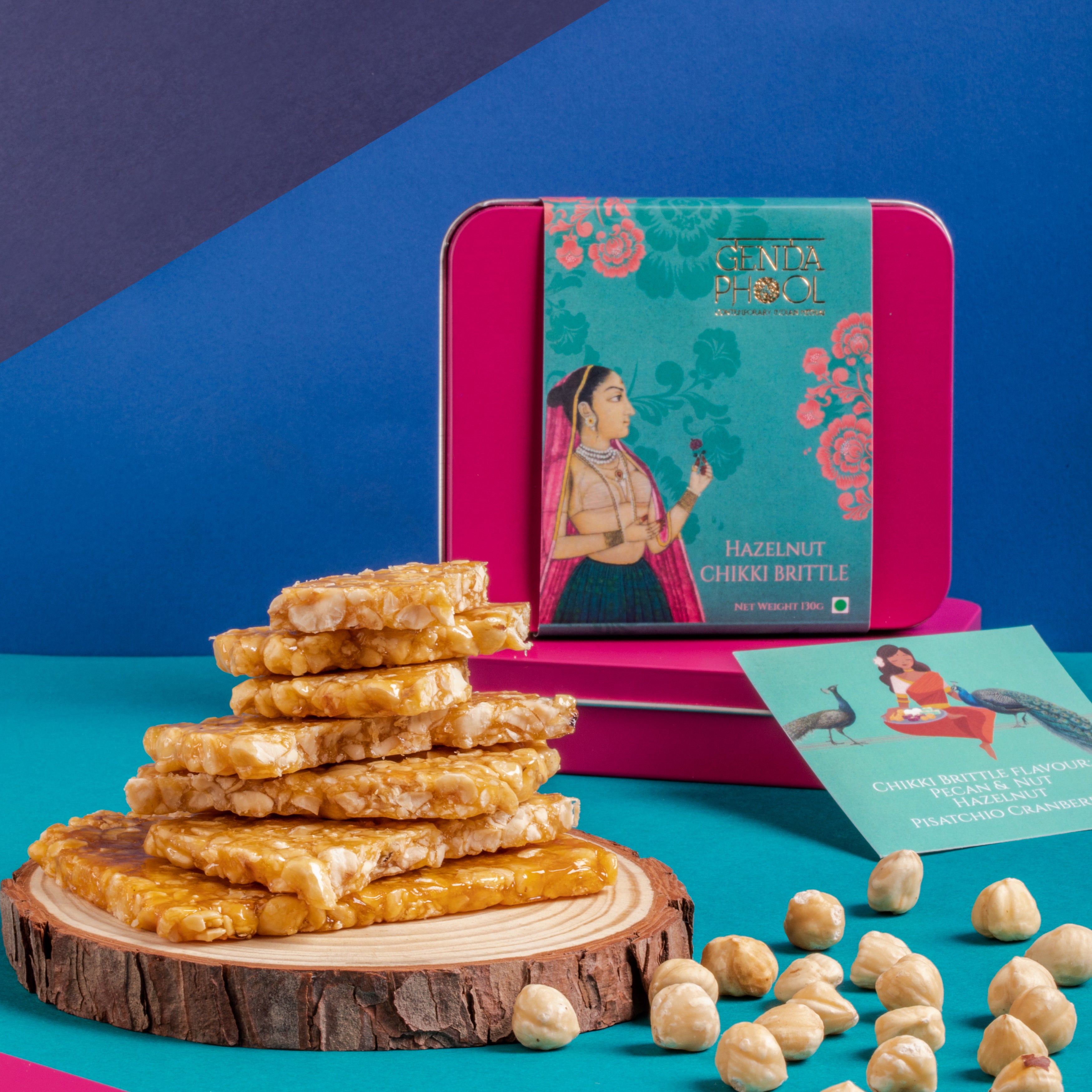 Hazelnut Chikki Brittle with an attractive and resuable tin on a blue background
